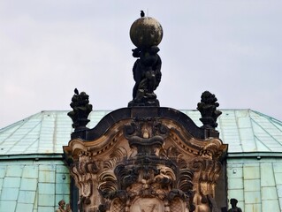 Decorative rooftop emblem. Ornamental rooftop detail featuring bronze textures and sculpted figures © Vladimir