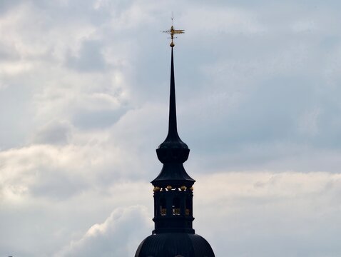 Sleek spire against cloudy backdrop. Refined and pointed tower amid moody sky with artistic framing