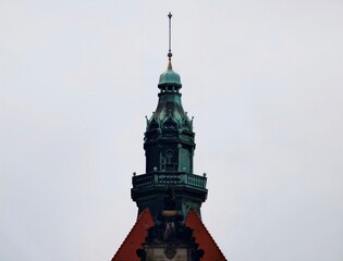 Fototapeta premium Quiet urban landscape showcasing vibrant green tower adorned with traditional building characteristics