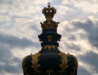 Grand monument with layered ornate banding. Architectural profile featuring stormy sky and regal crown © Vladimir