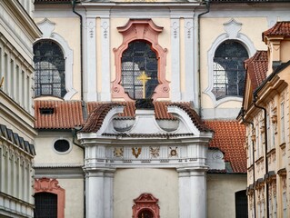 Intricate church entrance in alleyway setting. Refined baroque style church gateway tucked away © Vladimir