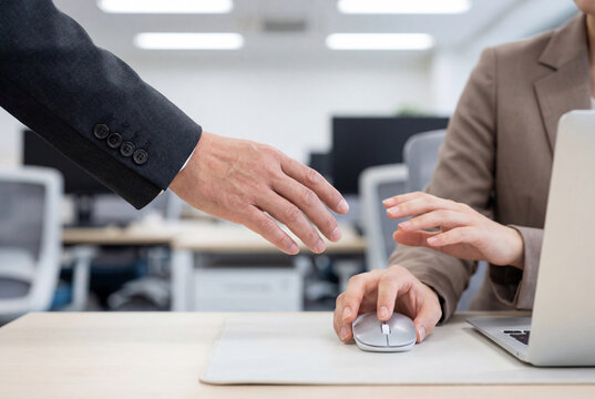 Male hand reaching towards female hand in a tense workplace situation