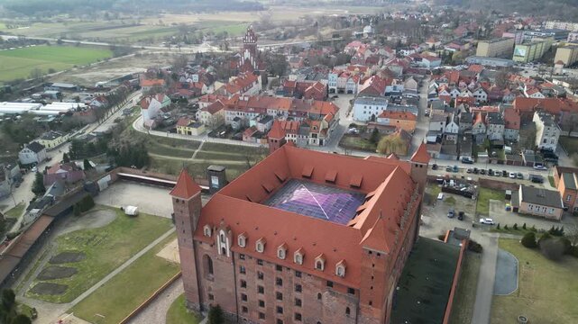 Gniew - Polska - stare miasto z pięknym kościołem i zamkiem krzyżackim nagrane dronem w słoneczny dzień