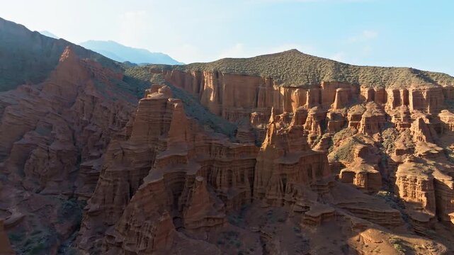 Aerial view captures stunning geological formations in Kyrgyzstan. Majestic canyon and mountains showcase natural erosion and serene landscape.