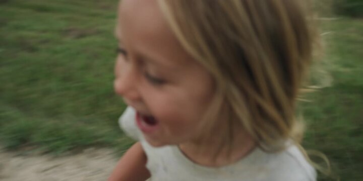 Young boy running in circles on a gravel road in the countryside