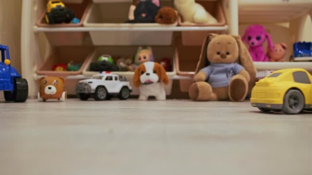 The toy train and car move on the floor in the playroom. Educational games for children using the concept of the "Vehicle" game set.