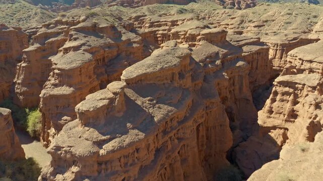 Dramatic sandstone canyons carve through arid landscape of Kyrgyzstan. Drone view.