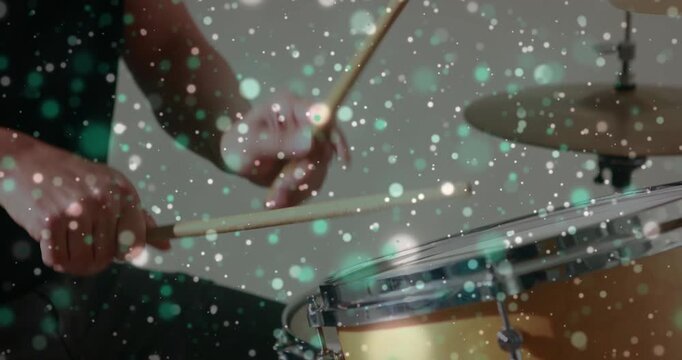 Drummer beginning by striking snare, music practice while particle overlay floating across hands