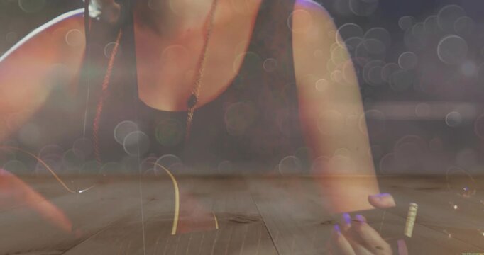 Female teen musician playing guitar and singing, camera rising revealing face with bokeh overlay