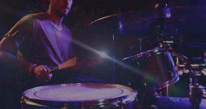 Drummer raising stick, playing snare-tom pattern for music set, grain overlay sweeping across kit