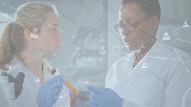 Left scientist holding tube, partner examining sample for research, network overlay covering team