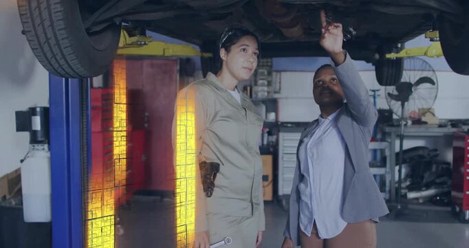 Supervisor raising hand shifting palm to finger guiding mechanic with wrench under car for repair