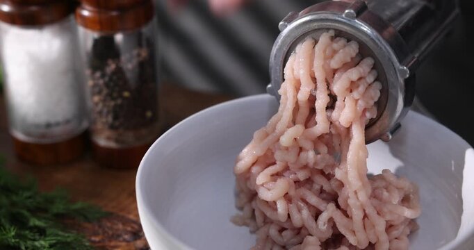 Man making minced meat with grinder at wooden table, selective focus