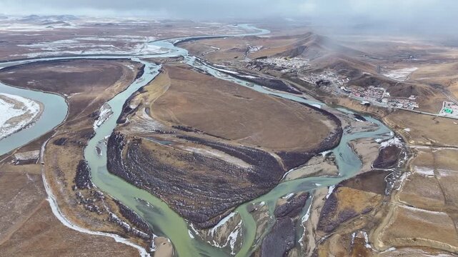 Aerial view of the First Bend of the Yellow River and Sogtsang Monastery, winter landscape with meandering river and snowy wetlands on the Tibetan Plateau