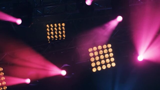 Colorful stage lights beams in concert scene, blue and pink spotlights with LED panels, dramatic lighting effects, live show atmosphere, performance background.