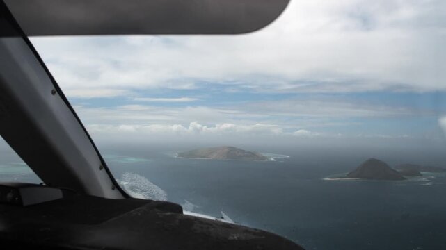 Aerial view of a tropical archipelago from a seaplane cockpit during a rainy day