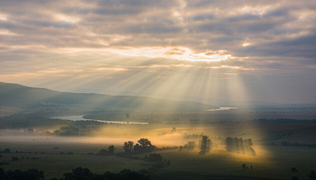Majestic sun rays over a foggy river valley landscape at dawn　夜明けの霧深い川の渓谷に差し込む、壮大な太陽の光線