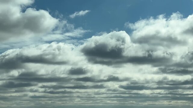 Layered cloud formations creating dramatic sky opening with blue patch symbolizing change and clarity