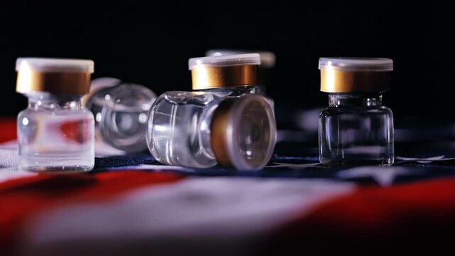 Several empty medical vials scattered on American flag fabric with subtle motion