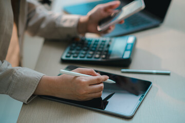 businesswoman using smartphone and tablet with calculator on desk, representing digital finance, accounting, online banking, budgeting, tax management and modern fintech workflow in office
