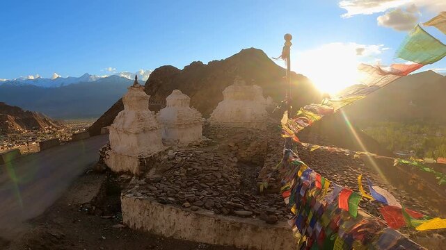uddhist Prayer Flags Waving in Wind with Himalayan Mountains and Stupas on Sunny Day