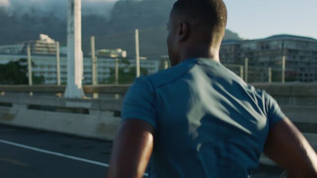 Running, training and black man in city, back and fitness for health benefits, routine or practice. Challenge, runner or person in street, cardio workout or exercise for wellness, endurance or energy