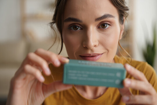 Woman showing a souvenir box to camera during a video call unboxing at home