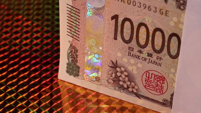 黄金の背景で回転する新一万円札の札束 クローズアップ