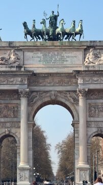 Arch of Peace, Milan: A grand triumphal arch, an iconic Milanese landmark, stands majestically under a clear blue sky, showcasing intricate sculptures and a captivating quadriga atop its structure.
