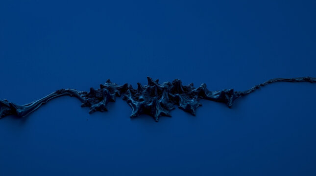 A dark blue background showcases a sinuous black abstract sculpture resembling flowing lava or twisted branches with tex
