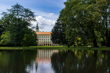 Obraz premium Kromeriz Archbishop's Palace reflecting on the calm surface of a lake in the castle garden. UNESCO historic architecture surrounded by mature trees in a summer park, idyllic