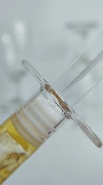 Yellow gel serum in syringe packaging, honey like texture facial cleanser isolated on white background with close up view.