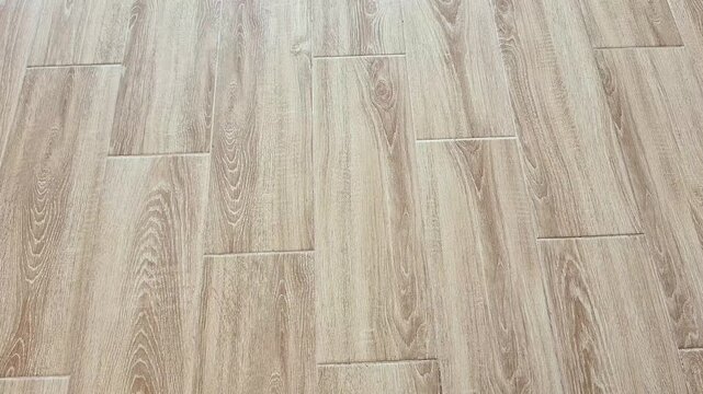 Light brown floor with staggered plank grain pattern, showcasing natural texture and clean finish, creating a simple, modern look with warm tones and visual appeal