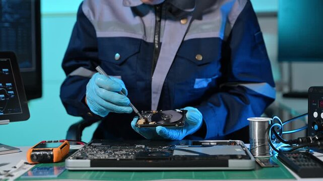 Technician repairing inside of hard disk drive by screwdriver. the concept of data, hardware, technician and technology. computer hardware, repairing, upgrade