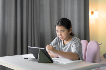 asian child smile learn from home by tablet and holding touch pen to learning drawing or writing on computer and study online class or kid girl people student fun studying on laptop by home school © kornnphoto
