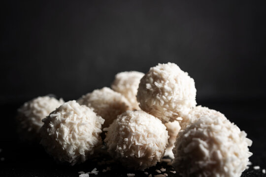 Coconut candies with nuts on dark background. Raffaello on black background. High quality photo