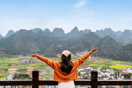 Young happy woman tourist enjoying the beautiful nature landscape with mountains while traveling in Wanfenglin in China, Wellness and travel concept