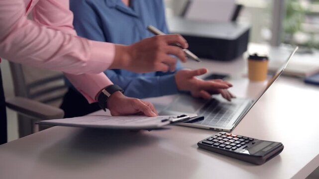 Asian business professionals discuss project using laptop collaborate meeting modern office workspace strategize partnership growth