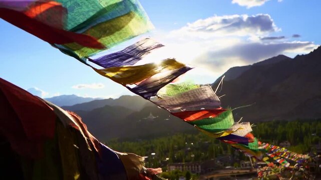 Buddhist Prayer Flags Waving in Wind with Himalayan Mountains and Stupas on Sunny Day