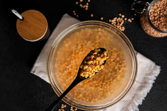 Bowl of yellow dried split peas on dark background. Yellow soaked peas. High quality photo
