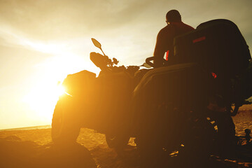 A man engages in extreme ATV riding on sand beach early in the morning © romaset