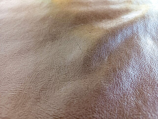 Fototapeta premium Abstract brown faux leather texture background with ripples. Dark leather surface with large copy space for text and luxury brand placement.