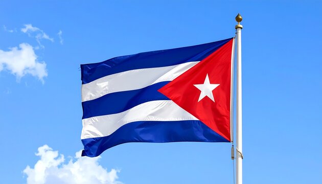 A vibrant Cuban flag, with horizontal blue and white stripes and a red triangle with a white star, flies proudly under a clear, bright blue sky