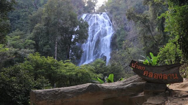 The video background features a natural setting with beautiful tourist attractions in Thailand, such as Khlong Lan Waterfall in Nakhon Nayok, which is always visited by travelers, both Thai and foreig