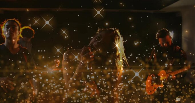 Lead singer performing music, starting line, whipping hair, leaning into mic, glitter rising