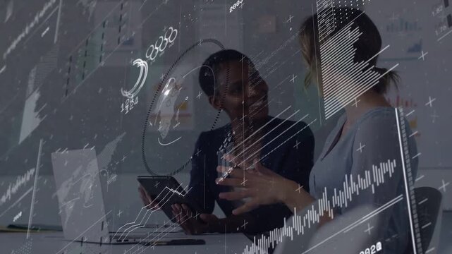 Left woman tapping tablet, right woman leaning, analyzing business metrics with HUD charts