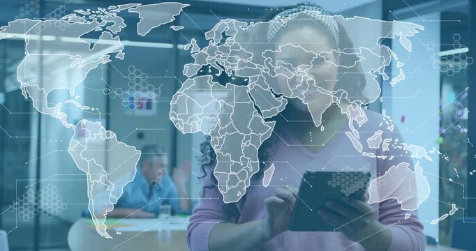 Woman tapping tablet and activating animated map overlay with hex grid, reviewing technology links
