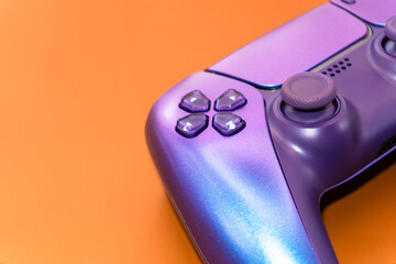 A gamepad for consoles on a dark orange background, gaming addiction, gaming ban for teenagers, gaming controls for parents, for banners and advertising. High quality © Karen Vardanian