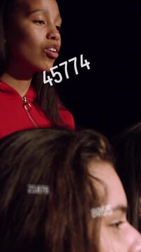 Vertical video: Red lead singing as numbers drifting over faces, camera pulling back for music art