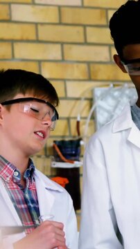 Vertical video: Lab student after peer cue lowering gaze and handling beaker preparing next step